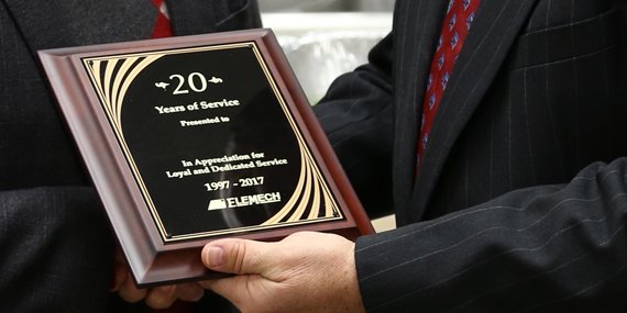 An EleMech employee receiving an award for 20 years of service.